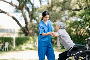 Asian young caregiver nurse support senior older female walking outdoors. Specialis doctor help and take care of elderly mature.