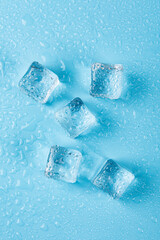 Ice cubes with water drops on a blue background.