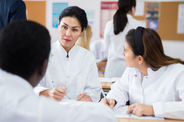 Medical academy students talking in class room