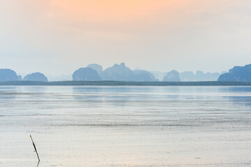 The distant mountains are complex, many with mangrove forests. There is a sea in front and a faint...