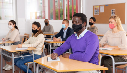 Portrait of adult aframerican man in protective face mask during lesson in extension school....