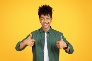 Studio headshot of happy african american man showing thumb up