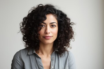 Portrait of a beautiful young woman with curly hair looking at camera