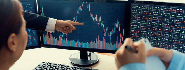 A cropped image of cooperate skilled business team discussion about stock investment while point the analysis stock chart. Show up and down trend. Stock market trading concept. Closeup. Burgeoning.