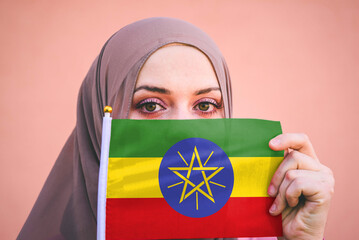 Muslim woman in hijab holds flag of Ethiopia
