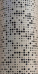 Curved perforated metal with a pattern made up of round circles