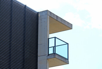 Abstract image of balcony of an apartment block with a concrete awning and glass balustrade