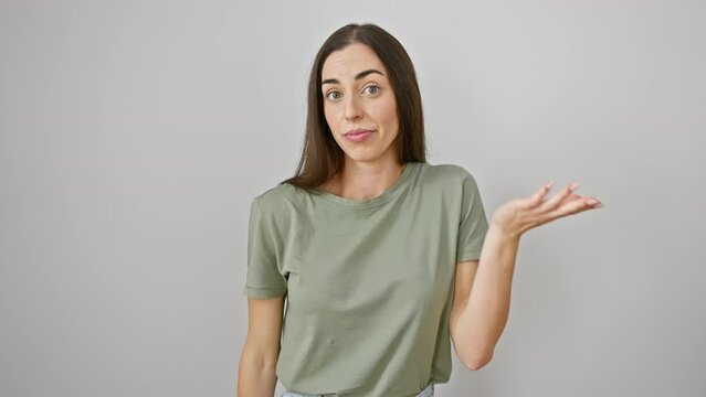 Frustrated young hispanic woman in casual clothes yelling a message, hand amplifying her loud scream to the side. beautiful portrait of stress communication over a white isolated background.