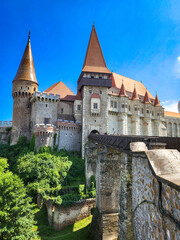 Fototapeta premium The famous Hunedoara Castle, Castelul Corvinilor or Corvin Castle with the Podul de Lemn castle bridge in summer with a blue sky, Hunedoara, Transylvania, Romania