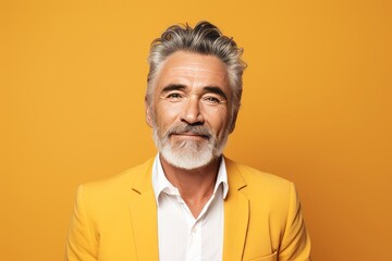 Portrait of handsome mature man in yellow jacket on yellow background.