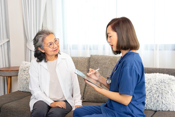 Obraz premium asian senior woman interested in a female nurse using digital tablet,giving advice self health care at home,concept of elderly health care,home care,home health care