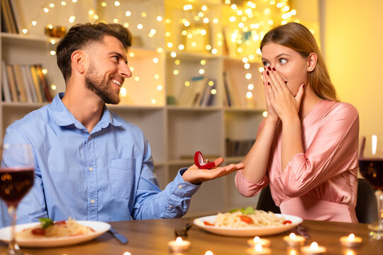 Man proposing with ring, woman shocked and happy