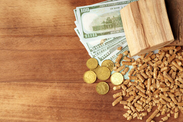 Dollar banknotes and wood pellets on wooden table