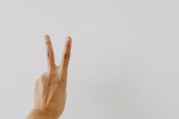 Image of woman's hand showing numbers two, counting fingers fighting and cheers up gesture, isolated on white background wall. 