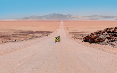 Fototapeta na wymiar SUV Vehicle rides through the sand dune Namib desert - Namibia