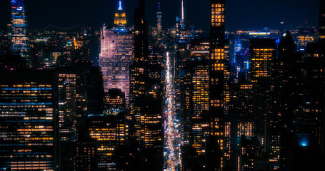 Fototapeta na wymiar Scenic Aerial New York City View of Downtown Manhattan Architecture. Panoramic Night Photo of the Business District from a Helicopter. Cityscape with Office Buildings and Busy Traffic on Streets