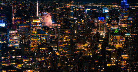 Establishing Helicopter Image of a New York City Architecture at Night. Long Lens Aerial View of Manhattan Entertainment and Business Districts, Urban Skyline with Skyscrapers in the Distance