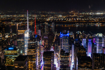 New York City Aerial Night Cityscape with Stunning Manhattan Landmarks, Skyscrapers and Residential Buildings. Wide Angle Panoramic Helicopter View of a Popular Travel Destination