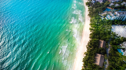 Aerial view of a tropical beach with turquoise waters and lush greenery, perfect for summer vacation concepts