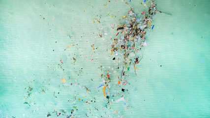 Aerial view of ocean pollution with scattered plastic and debris, highlighting environmental...