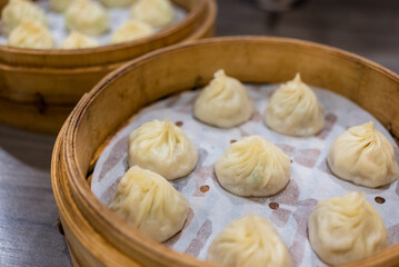 Fototapeta na wymiar Steamed xiaolongbao served in a traditional steaming basket