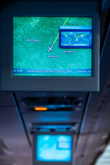 In flight An overhead display in an airplane cabin showing journey progress with text in German.