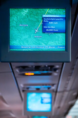 In flight An overhead display in an airplane cabin showing journey progress with text in German.