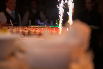 This photograph captures a festive moment at a celebration, with a focus on a dessert display...