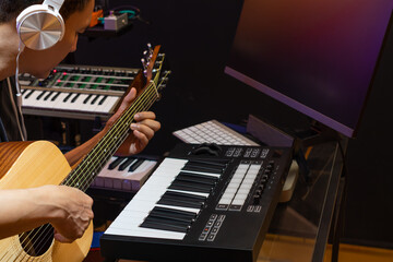 asian male musician, composer, artist enjoy playing acoustic guitar for recording on computer in home studio. music production or music e-learning on internet concept - 707658250