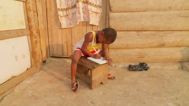 Africa poor village female kid studying at home learning writing educational system and school in undeveloped african countries
