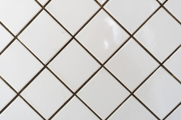 White wall tile pattern for decoration. Close-up vintage bathroom ceramic square tiles with defects