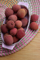 Lychee or Litchi in a pink porcelain bowl on wooden table