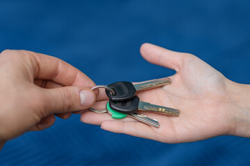 Przekazywanie kluczy do mieszkania, zbliżenie na dłonie i pęk kluczy