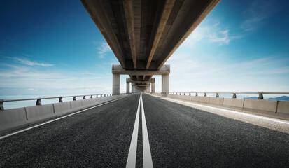 Highway road under the overpass with clear blue sky. - obrazy, fototapety, plakaty