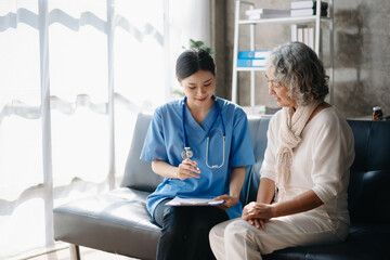 Asian Doctors explain the use of medication to patients. Medical doctor holing senior patient's...