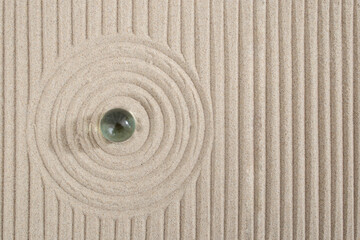 Fototapeta na wymiar Miniature sand zen garden with a glass sphere , circles and lines dunes, abstract texture backdrop