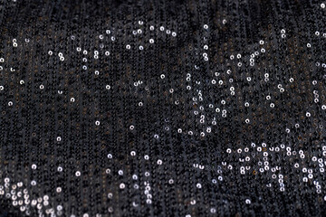 a large number of sequins on a black material - obrazy, fototapety, plakaty