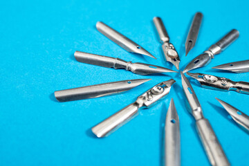 Multiple vintage pen nibs pointing to the same direction, teamwork concept, soft focus close up