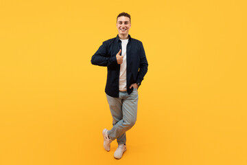 Fototapeta na wymiar Positive young european man showing thumb up and smiling