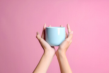 Woman hands holding blue cup mockup for text or branding isolated over pink background