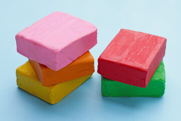 Colorful plasticine clay on blue background.