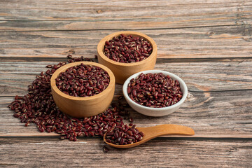 Red kidney beans in white cup and wood cup on wooden background