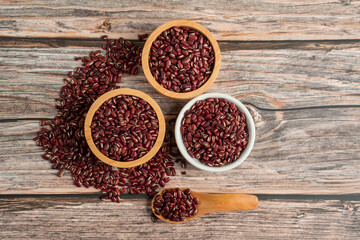 Red kidney beans in white cup and wood cup on wooden background