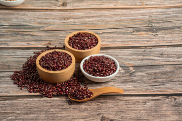Red kidney beans in white cup and wood cup on wooden background