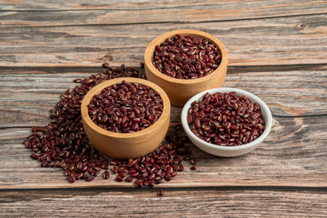 Red kidney beans in white cup and wood cup on wooden background