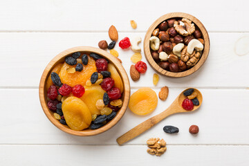 healthy snack: mixed nuts and dried fruits in bowl on table background, almond, pineapple,...