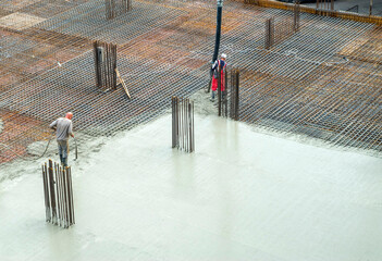 Concrete casting on reinforcing metal bars of a slab in building