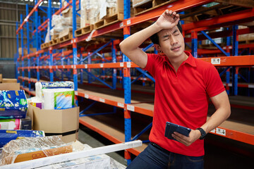 worker feeling tired and have a headache from work in the warehouse storage