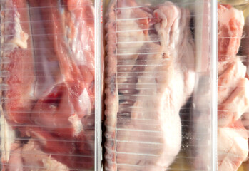Fresh raw meat in package in plastic box, Close-up of meat in plate over light background