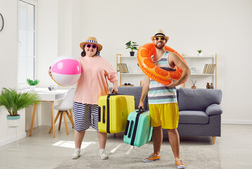 Funny happy family couple get ready for vacation trip. Smiling man and obese, overweight woman in...